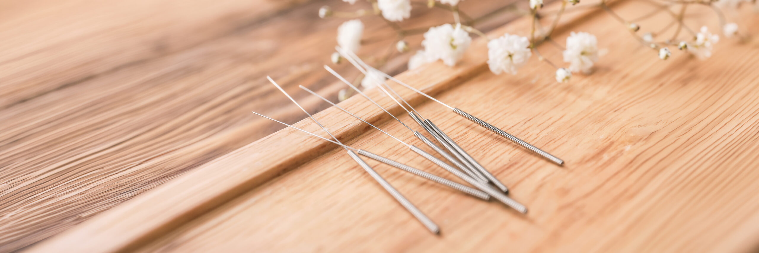 Stand with acupuncture needles on wooden background, closeup